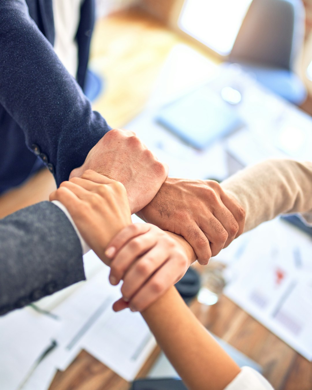 Colleagues joining hands in a chain, symbolizing an aligned organization